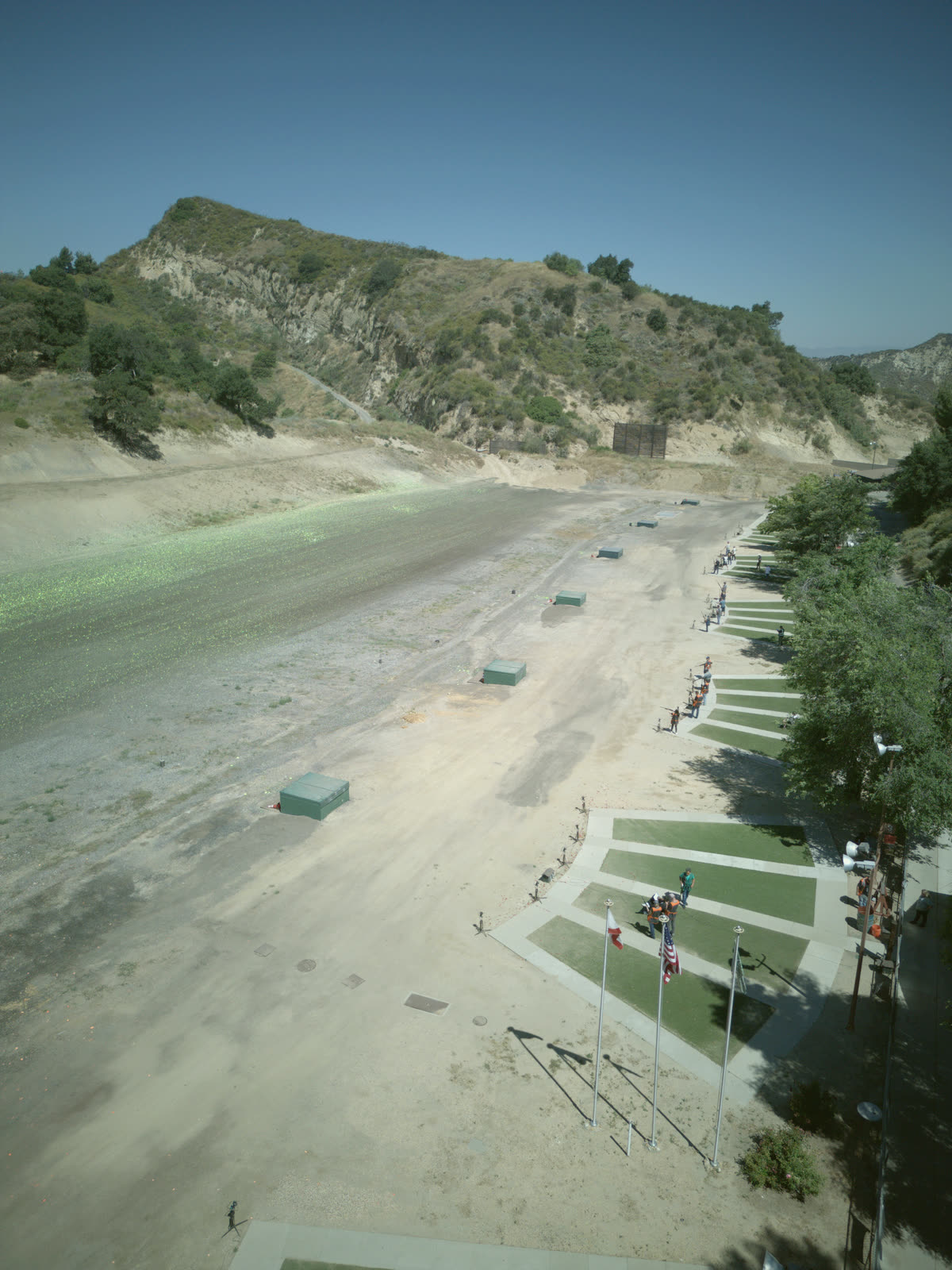 The trap line from the air: the pads and their shooters along the right, the trap houses on the field and the hill beyond.